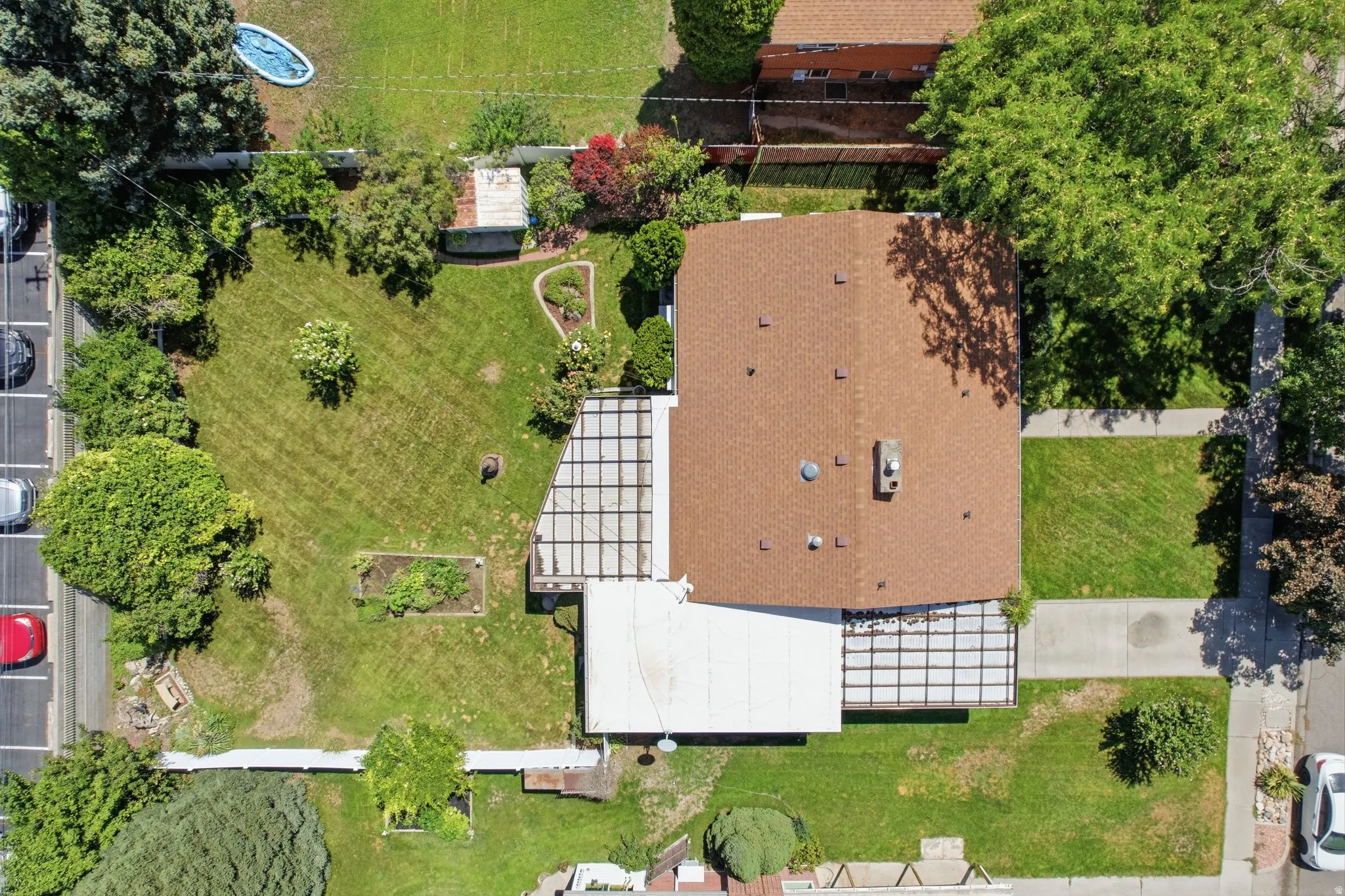 Expansive rear yard with mature trees, established landscaping, and a paved patio