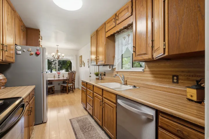 Kitchen featuring wood-finish cabinetry, light wood-finish countertops, and stainless steel appliances