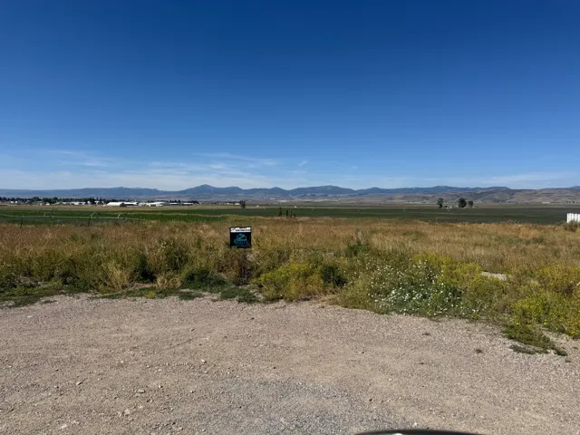 Expansive open land with distant mountain ranges and a clear sky