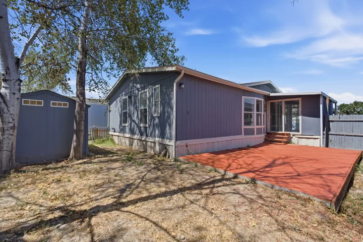 Expansive wood deck with stairs, double pane glass sliding door, and a detached storage shed
