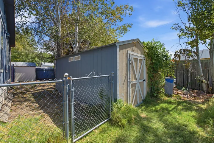Storage shed with two visible vents, chain link fencing.