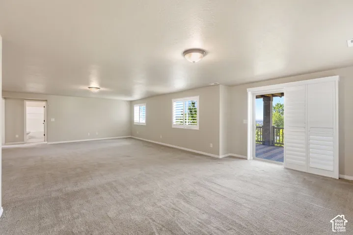 Spacious room with neutral carpeting and light-toned walls