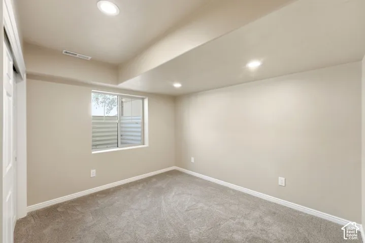 Recessed lighting, wall-to-wall carpeting, and a window with a window well
