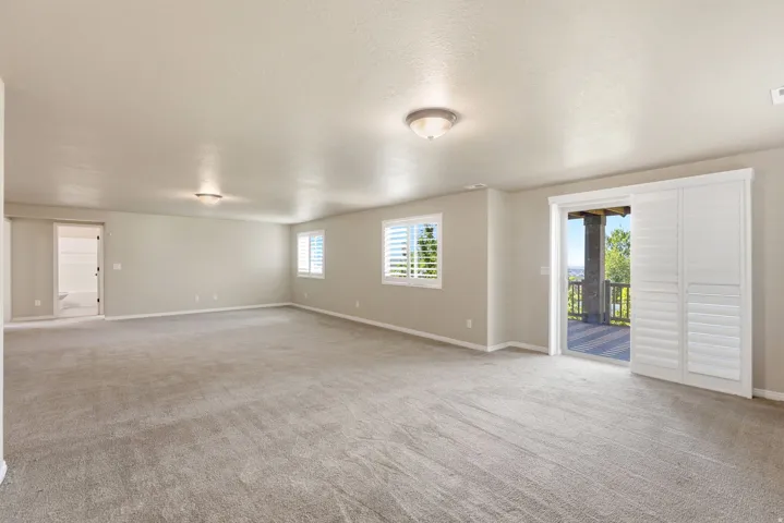 Spacious room with neutral carpeting and light-toned walls