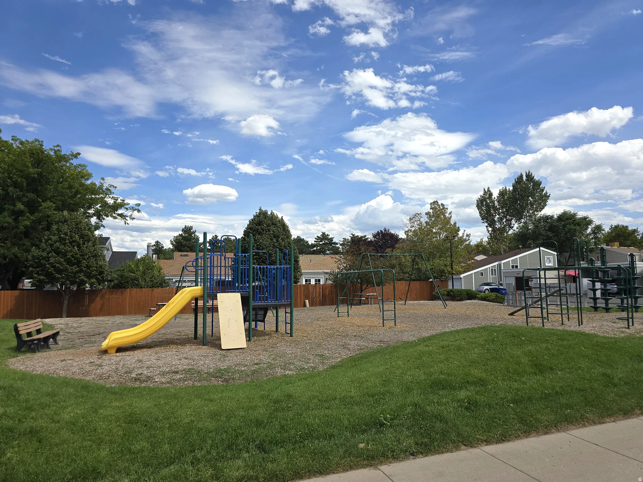 Community playground featuring a yellow slide and swing set