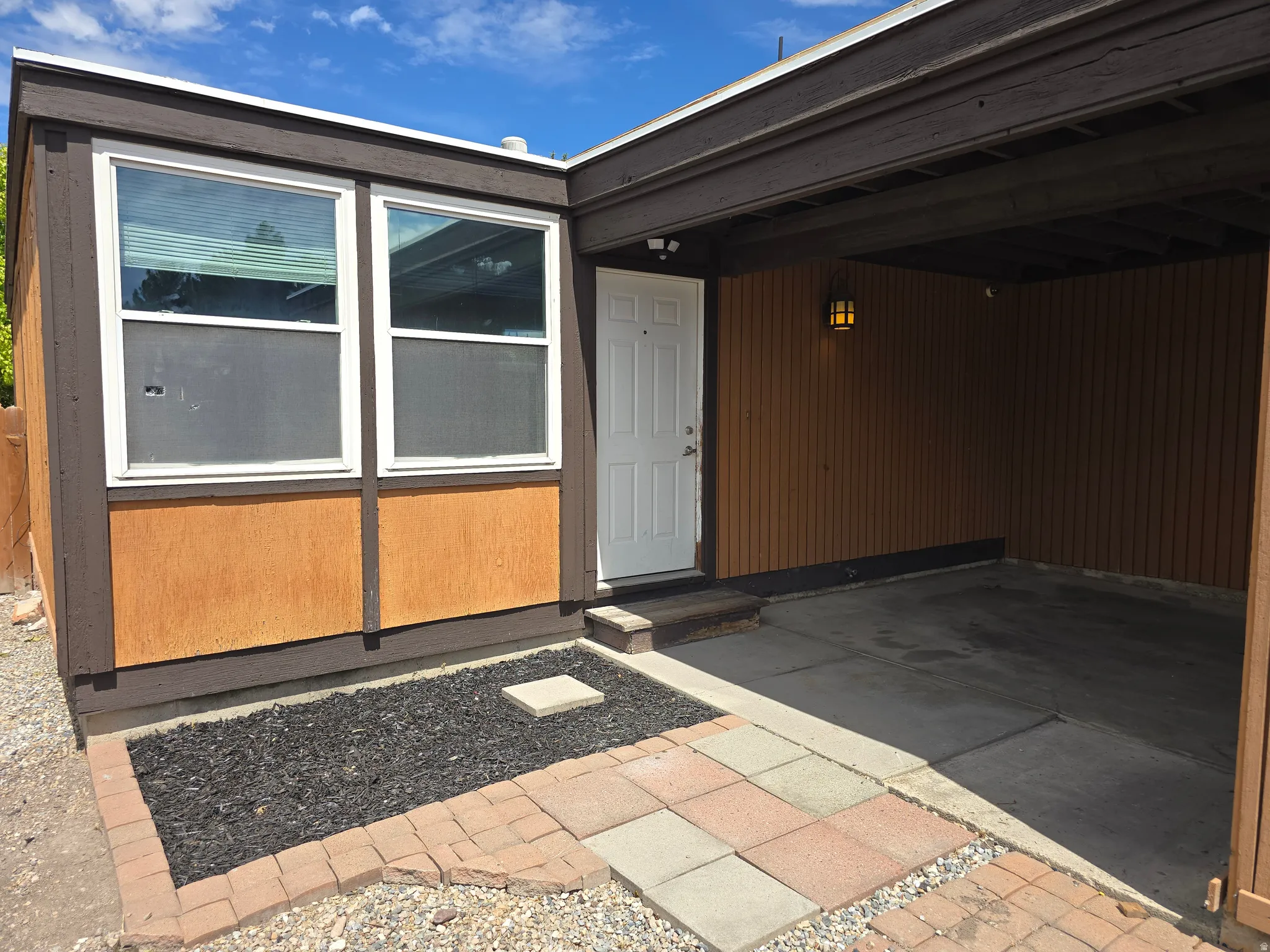 Covered entrance with exterior wall lantern and white entry door