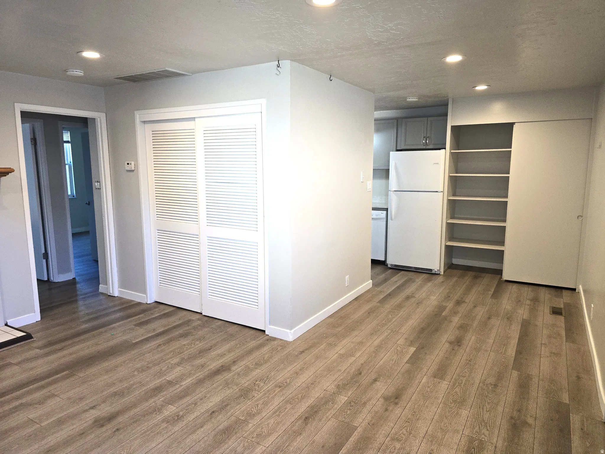 Open concept living area featuring wood-finish flooring, recessed lighting, and built-in shelving