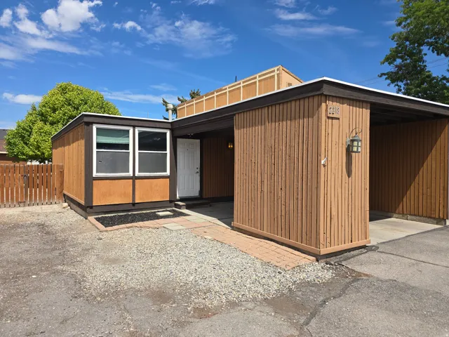 Exterior featuring vertical wood-finish siding and a covered carport
