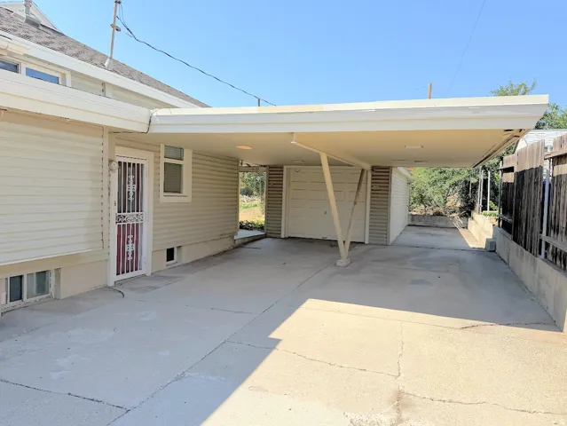 Covered concrete carport with a garage door access