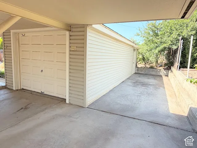 Attached garage with a panel-style door, concrete flooring, and horizontal siding