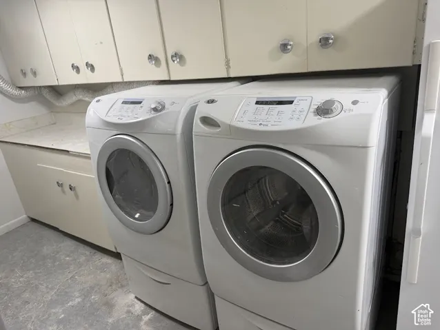 Laundry area featuring off-white upper and lower cabinetry, laminate countertops, and hard-surface flooring
