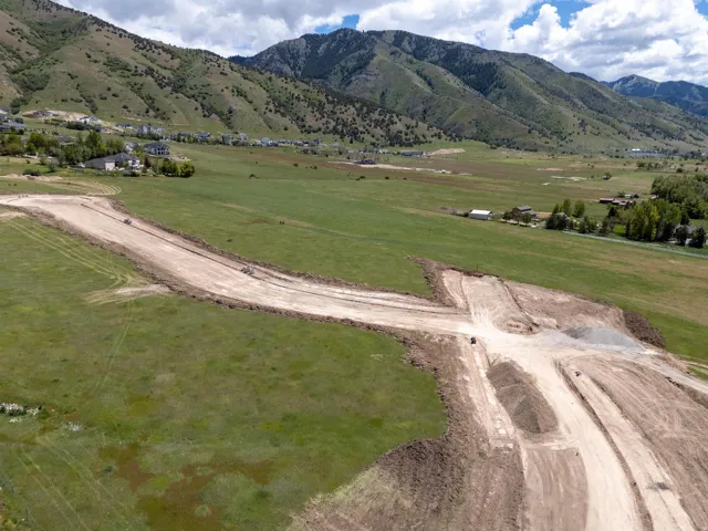 Expansive land parcel with graded roads and mountain backdrop