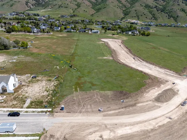 Grading in progress for future development, surrounded by green landscape and distant mountainous terrain