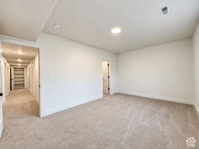 Neutral wall paint, recessed lighting, and soft carpeting