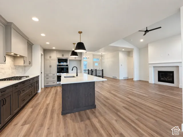 Wood-finish flooring, recessed lighting, and a vaulted ceiling