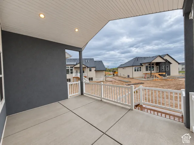 Covered patio with recessed lighting, concrete flooring, and white railing