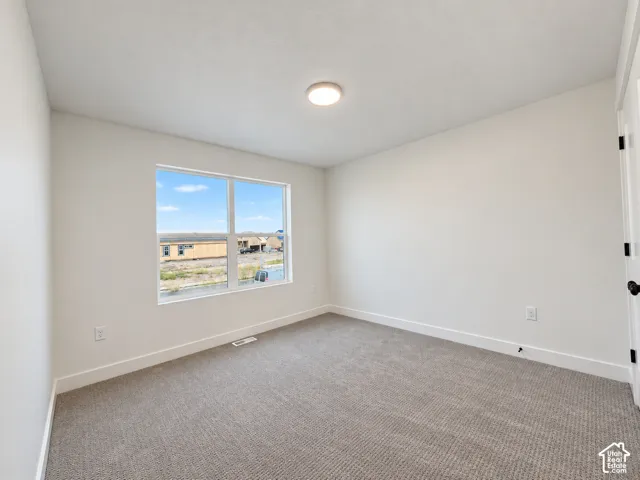 Neutral-toned wall-to-wall carpeting complements the white walls and trim