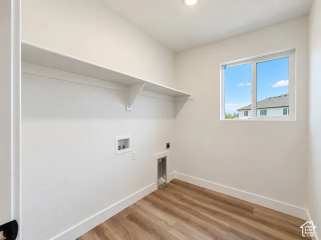 Wood-finish flooring, white walls, built-in shelving, and a window