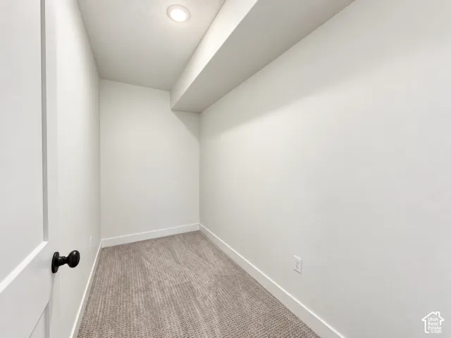 Recessed ceiling lighting, white interior walls, and carpet flooring