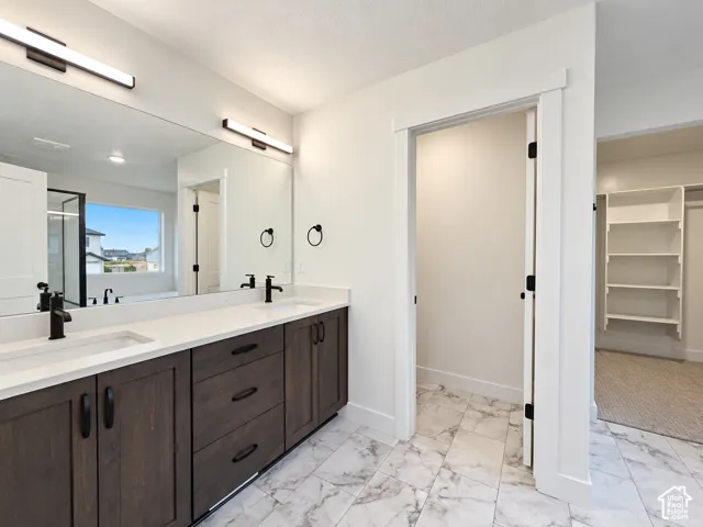 Dual vanity with dark wood-finish cabinetry, white countertops, and matte black fixtures