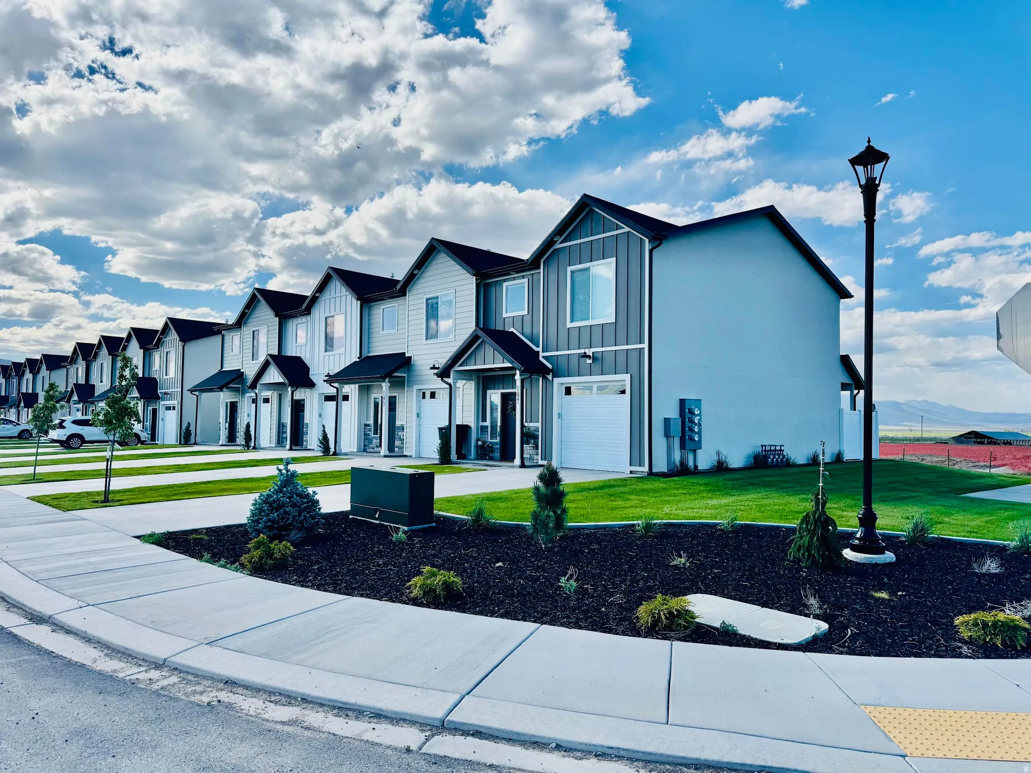 Two-story residences with attached garages, manicured lawns, and concrete sidewalks
