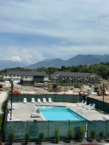 Fenced swimming pool with a surrounding concrete deck and mountain scenery