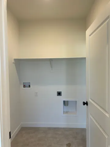 Laundry area featuring a utility shelf, washer hookup, dryer hookup, and carpet flooring