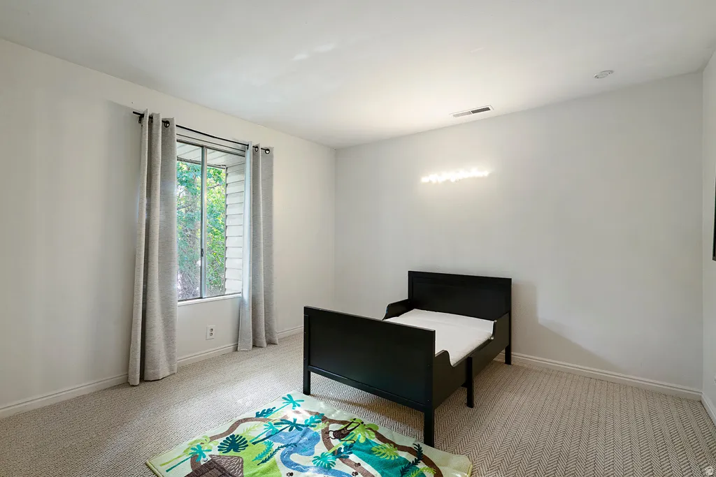 Window with exterior foliage, wall-to-wall carpeting, and recessed lighting