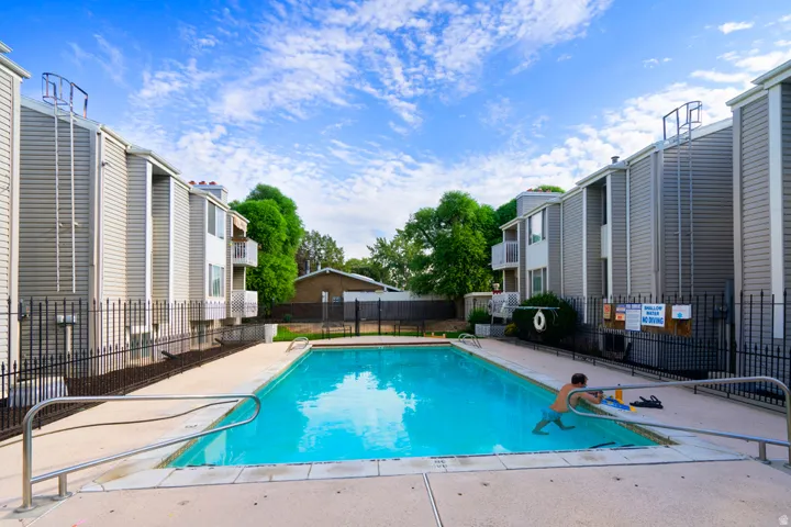 Rectangular swimming pool with light-colored coping and metal handrails