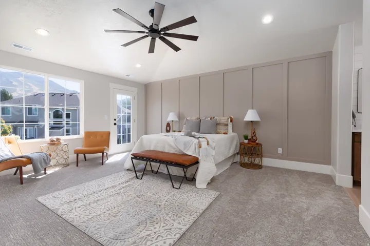 Vaulted ceiling with a contemporary ceiling fan, recessed lighting, expansive window, board and batten accent wall, and a glass-paneled door
