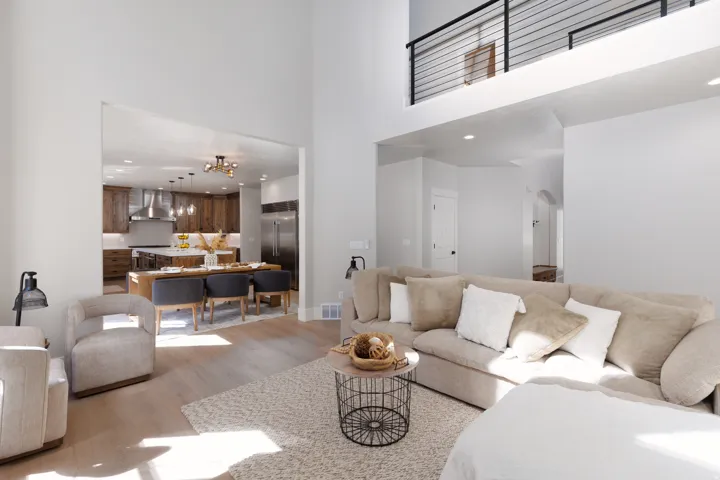 Open-concept living area featuring high ceilings, wood-finish flooring, and a modern kitchen with stainless steel appliances and wood cabinetry