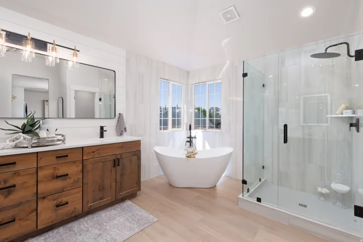 Dual-sink vanity with wood-finish cabinetry, quartz countertop, and rectangular mirror