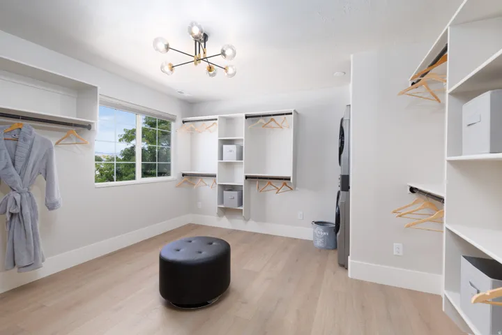 Built-in closet organization systems, wood-finish flooring, recessed lighting, modern ceiling fixture, and a window with exterior scenery