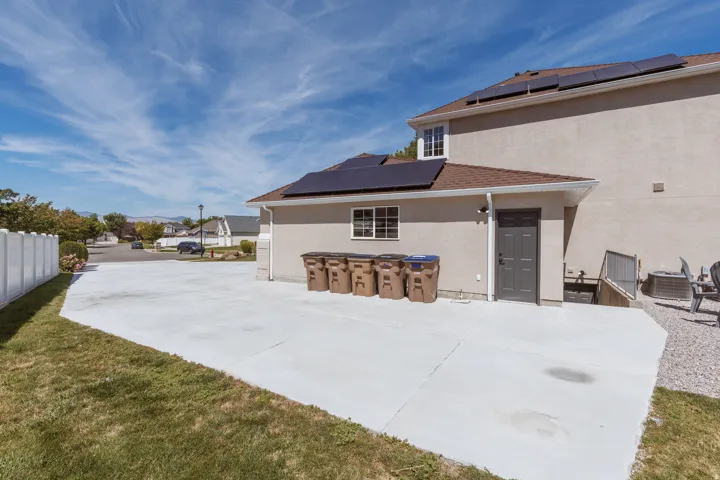 Expansive concrete patio with a stucco exterior and solar panels