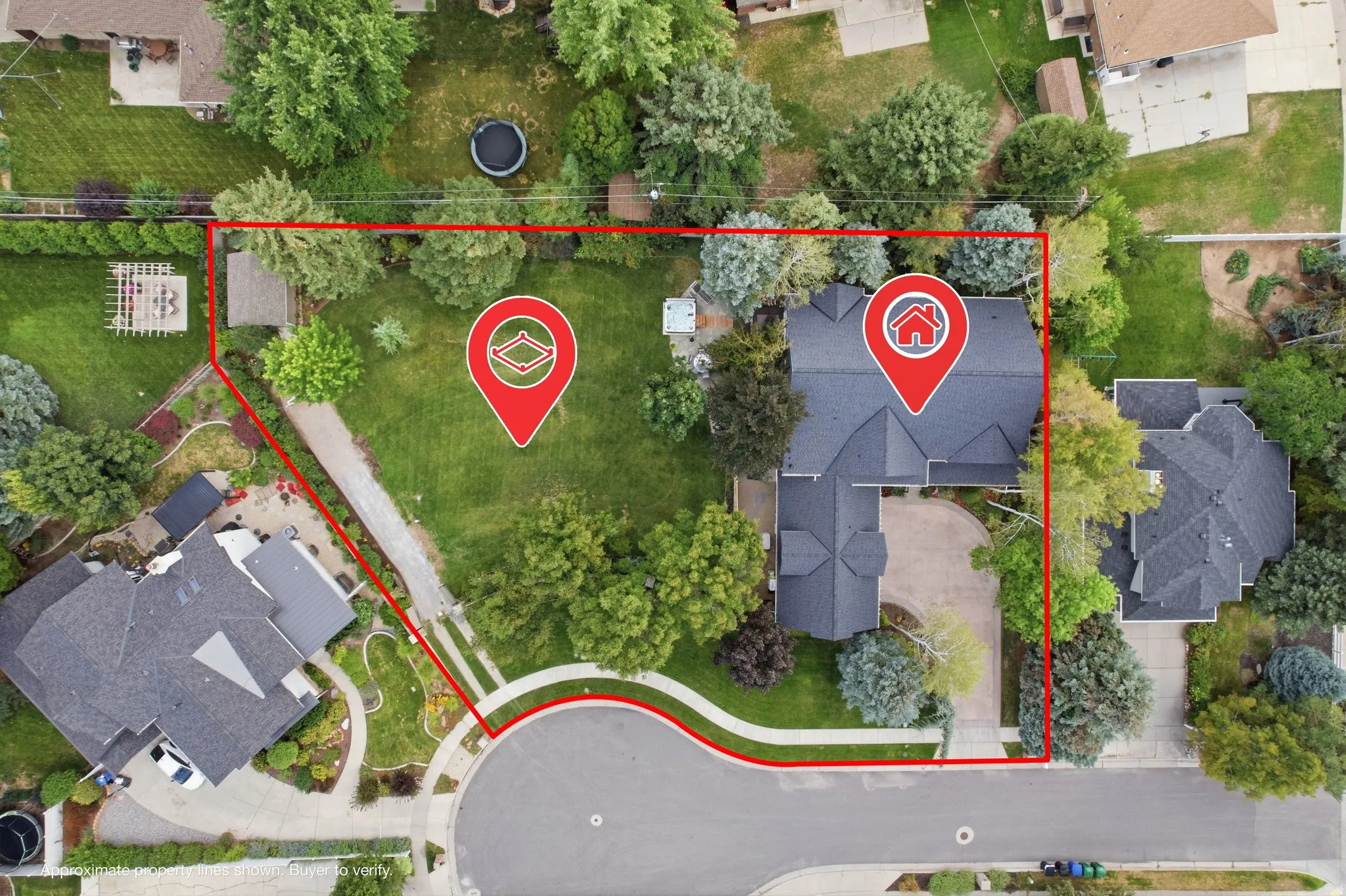 Expansive property featuring a curved driveway, mature trees, and a detached structure