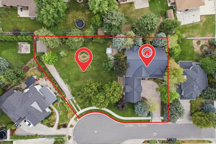 Expansive property featuring a curved driveway, mature trees, and a detached structure