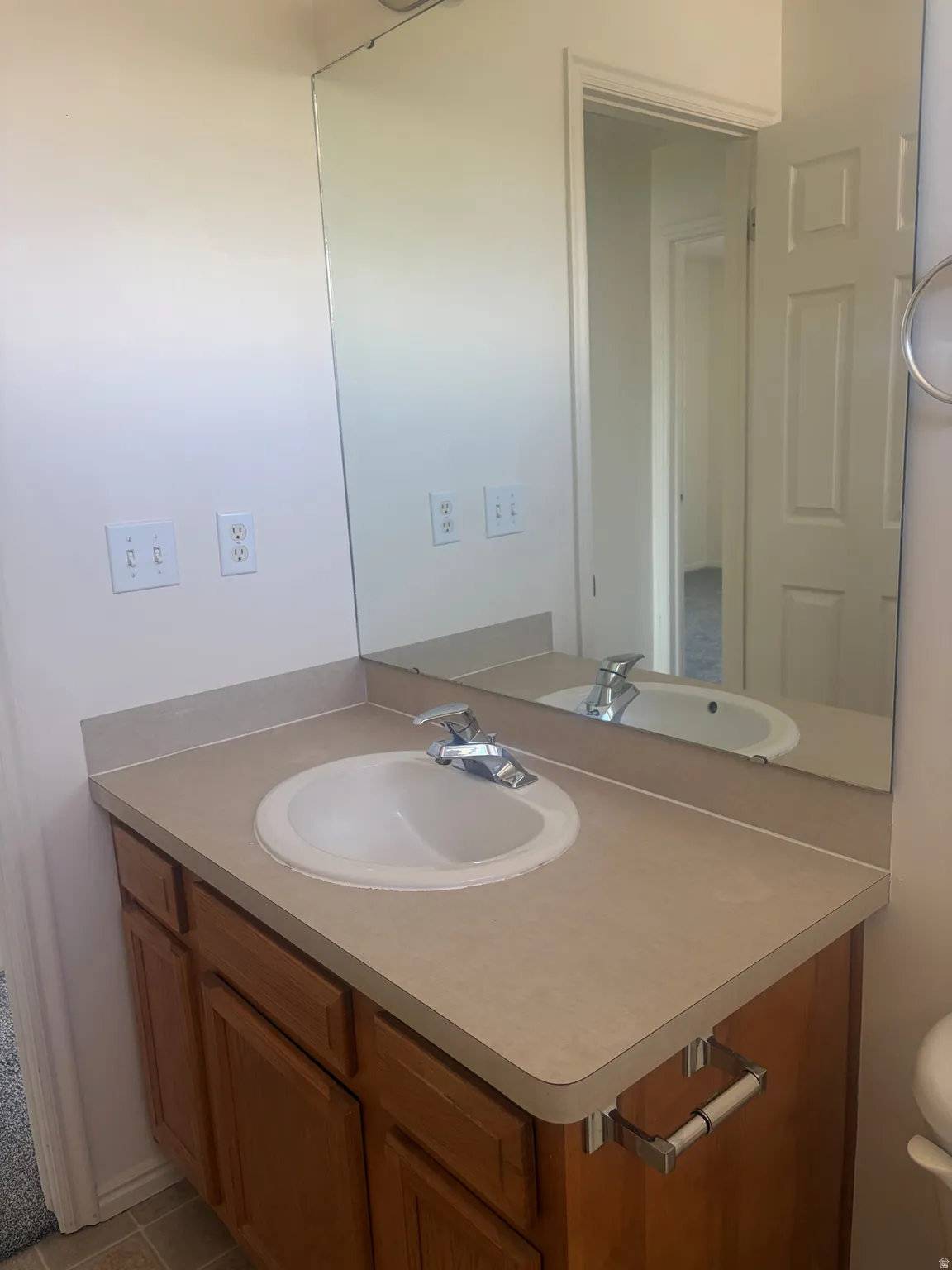 Vanity with a laminate countertop, an integrated sink, and wood-finish cabinetry