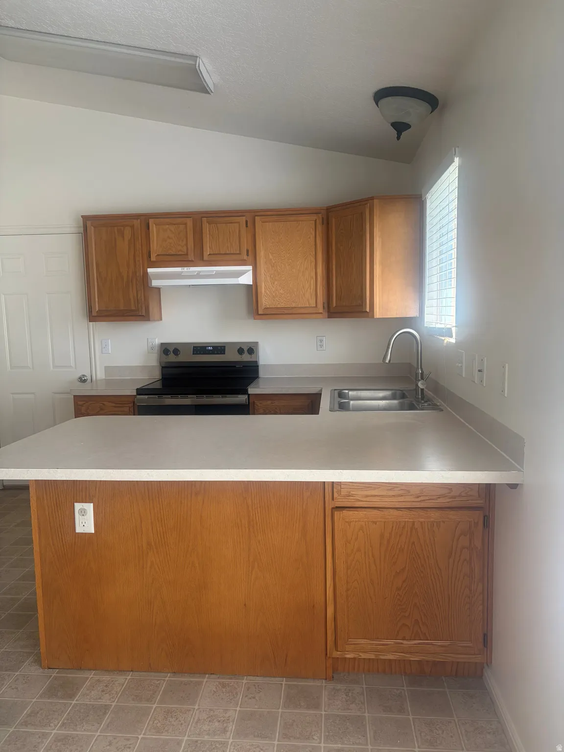 Kitchen featuring wood cabinetry, laminate countertops, and stainless steel appliances