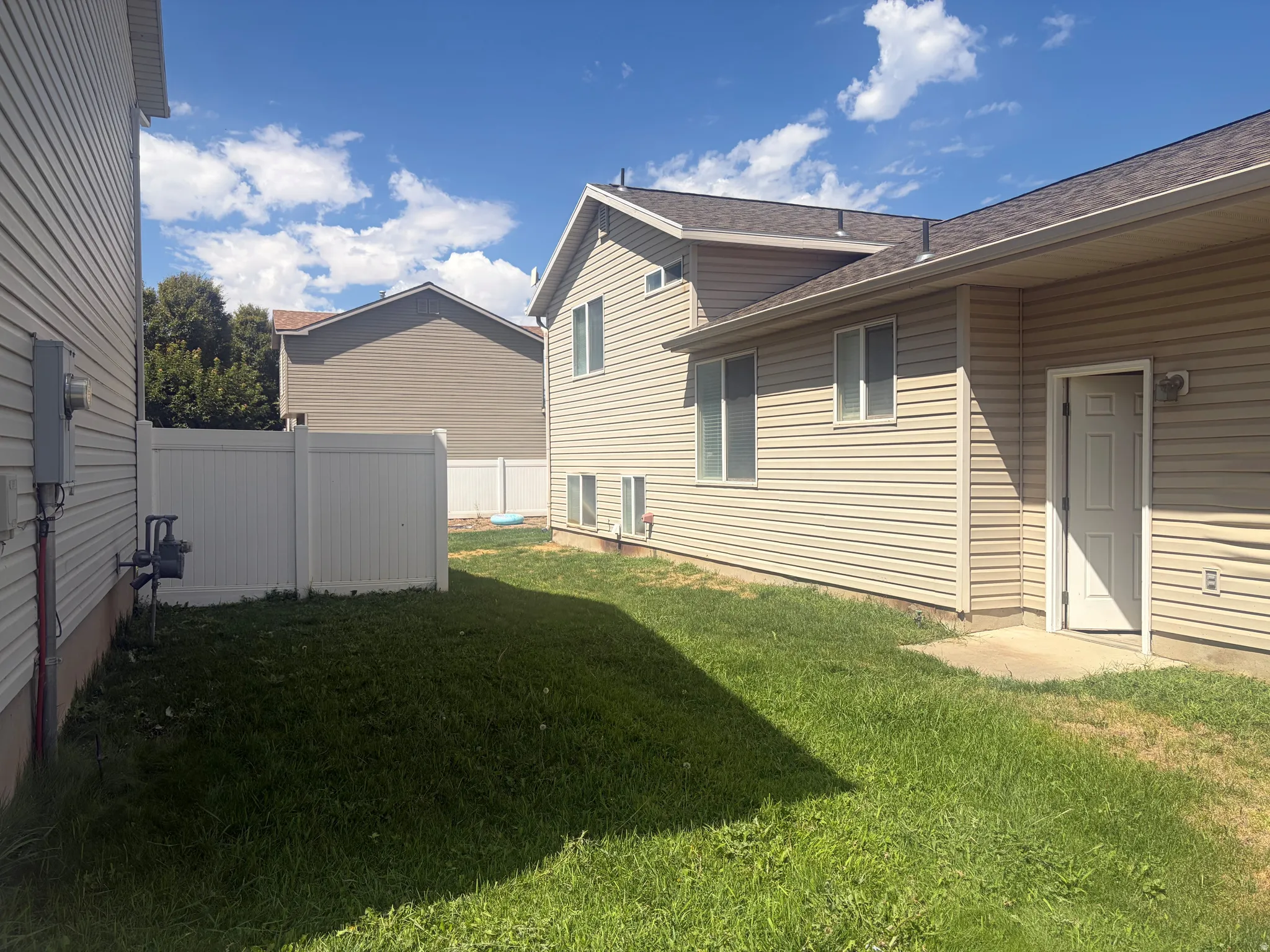 Enclosed yard featuring a white vinyl fence
