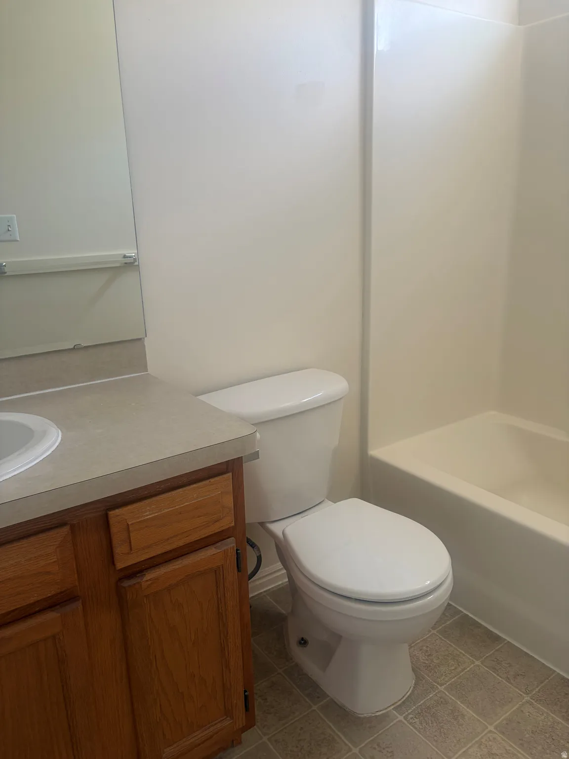 Bathroom featuring a vanity with a light-toned countertop, integrated sink, and wood-finish cabinetry