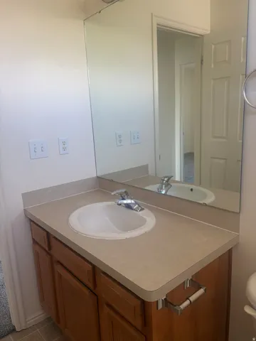 Vanity with a laminate countertop, an integrated sink, and wood-finish cabinetry