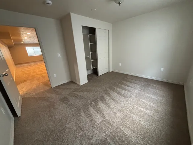 Neutral-toned walls complement the textured carpeting
