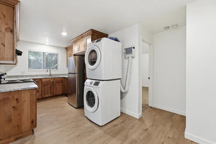 Kitchen featuring wood cabinetry, light-toned countertops, and a stainless steel refrigerator