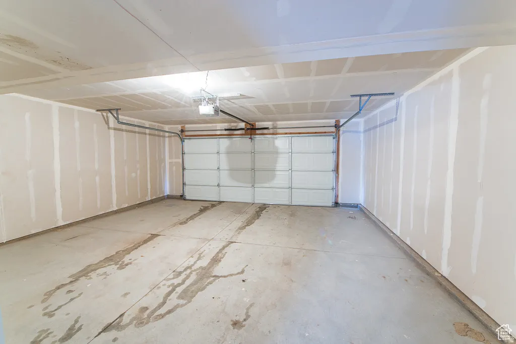 Attached two-car garage featuring a sectional overhead door and concrete flooring