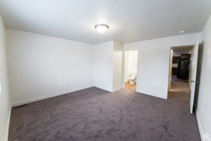 Spacious room with plush carpet flooring, neutral paint palette, and flush mount lighting