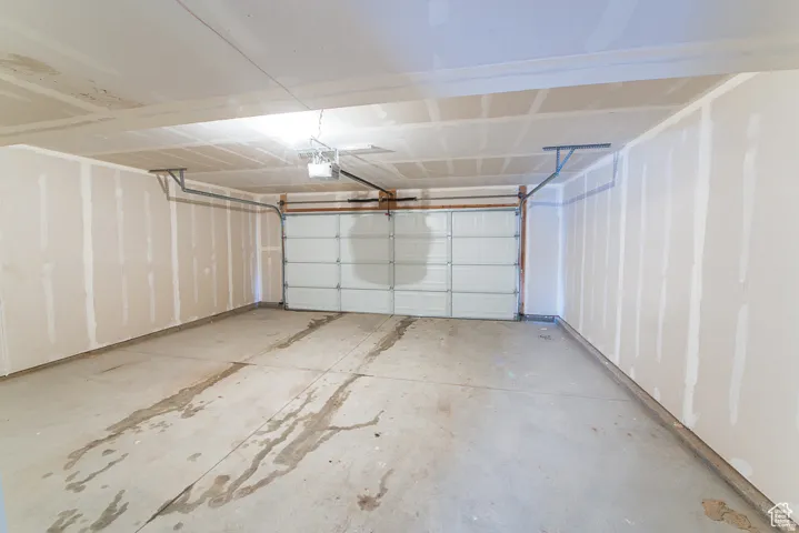 Attached two-car garage featuring a sectional overhead door and concrete flooring