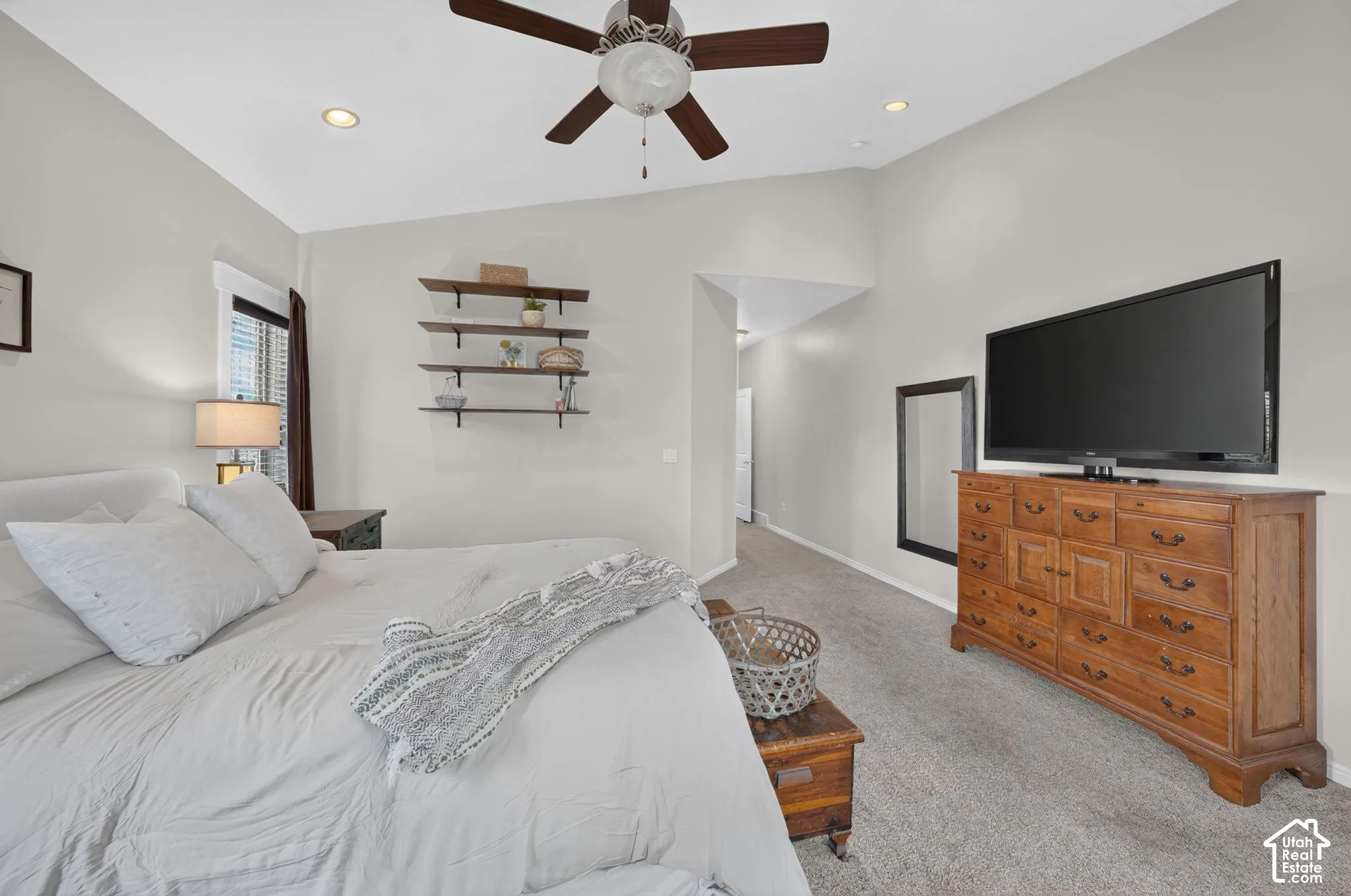 Vaulted ceiling, recessed lighting, ceiling fan, wall-mounted shelving, and carpeted flooring