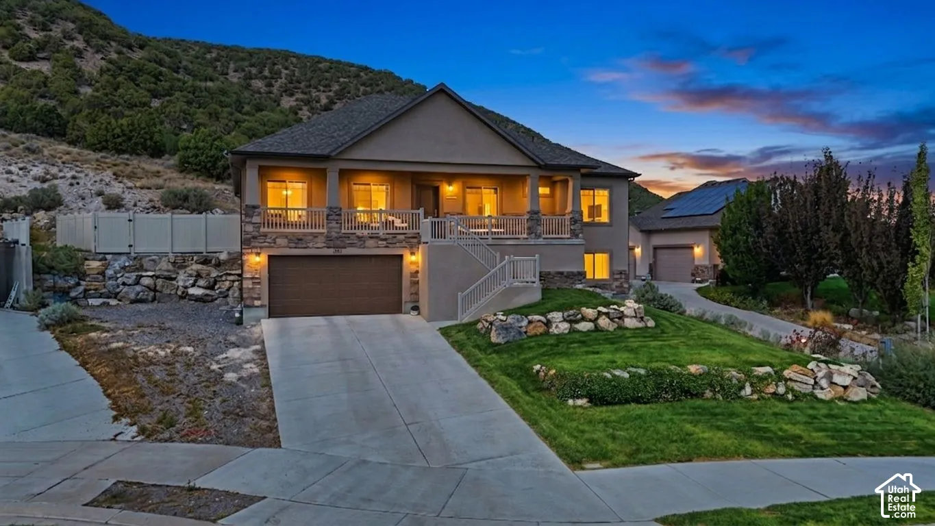 Multi-level exterior with stone accents, a covered front porch, and an integrated garage
