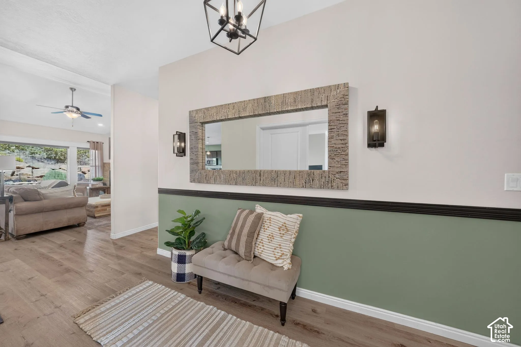 Wood-finish flooring, accent wall with chair rail, recessed ceiling, modern ceiling fan, and contemporary light fixtures
