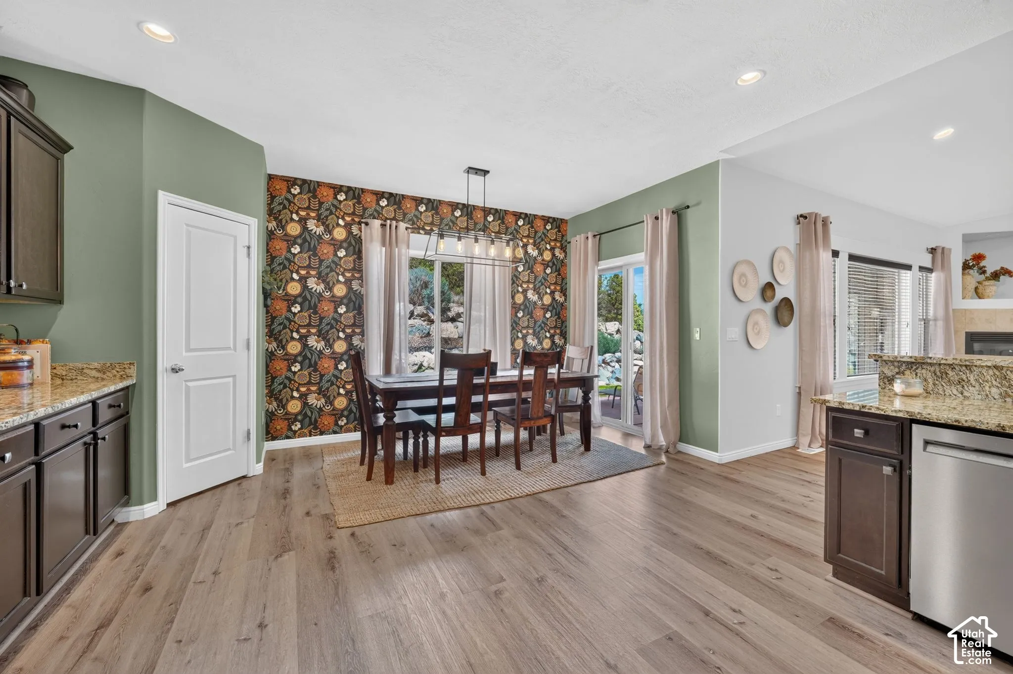 Open-concept living area with wood-finish flooring, recessed lighting, and sliding glass doors